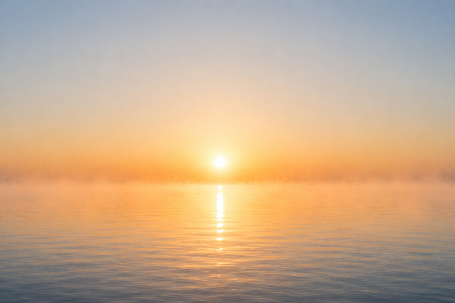 Sunrise over misty water